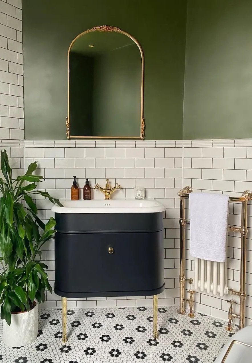 Après : salle de bains en carrelage métro blanc et peinture vert profond, meuble vasque suspendu bleu nuit, robinetterie et sèche-serviettes laiton, sol en tomettes hexagonales